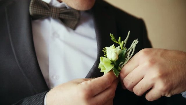 Groom takes wedding boutonniere to suit