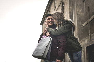 Couple in shopping together. Cheerful couple standing on street. Looking each other.