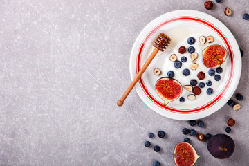 Yogurt with berries fresh figs, blueberries and honey.Food or Healthy diet concept.Super Food.Top View.Copy space for Text.selective focus.