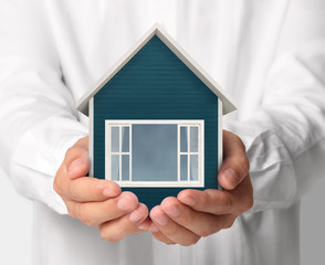 Mortgage concept by house from  hand