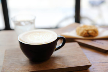 cappuccino coffee with cookie on wood background
