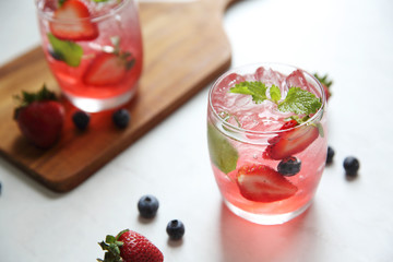 Strawberry juice cocktail with ice and mint on white tone amd wooden