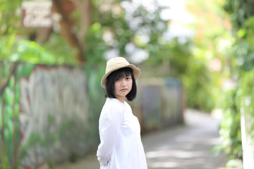 Asian young woman thinking and looking portrait with green tree background