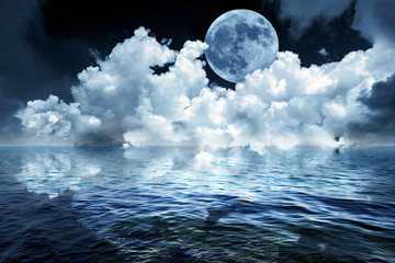 Naklejka premium Big full moon in night sky over the ocean reflecting in calm water