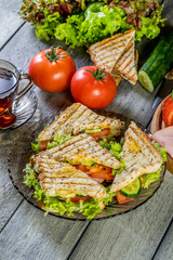 Panini sandwich with ham, tomato and lettuce.