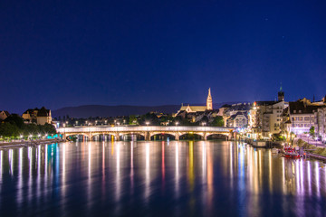 Night view of the Old Town of Basel with red stone Munster cathedral and the Rhine river, Switzerland.