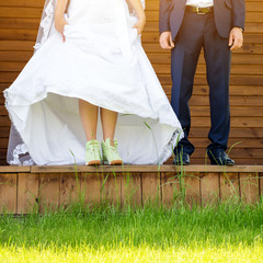 Funny beautiful wedding couple. Bride wearing green running shoes. Runaway Bride, close up.