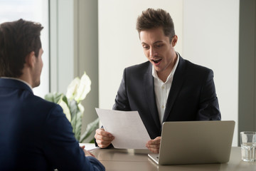 Excited recruiter impressed by career achievements in resume of applicant, surprised businessman...