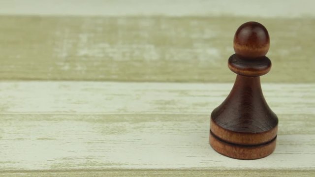 Chess pawn on a wooden background