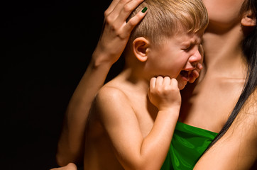 Portrait of a beautiful crying child on the mother's arms