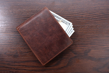 Wallet with money on wooden background