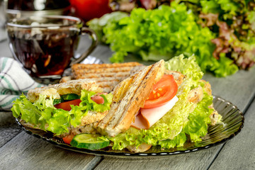Panini sandwich with ham, tomato and lettuce.