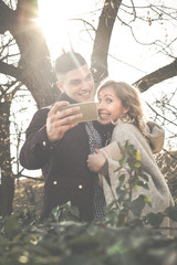 Young couple making self-picture. Happy couple having fun in the park.
