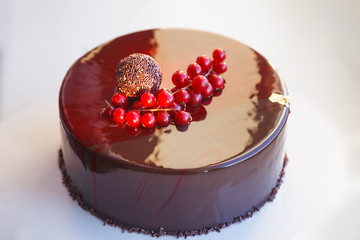 Ombre marble mousse cake decorated with red mirror glaze and berries. Modern dessert. Natural light
