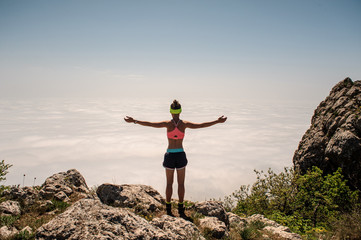Obraz premium woman enjoying the nature in the mountains and looking on sky with raised hands.