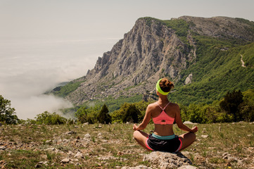 Naklejka premium Young girl doing yoga fitness exercise outdoor in mountains landscape.