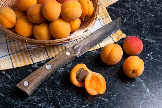Fresh organic apricots in basket. Group of harvested apricots in basket with vintage knife..