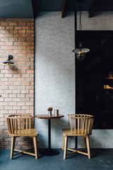 Cafe outdoor furniture interior loft style with cement and brick wall, blank space wall to put logo.