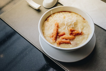 Hong Kong Congee in white bowl served with chinese doughnut chineseand Light Soya sauce in morning, Rice porridge, Rice gruel, Rice soup.