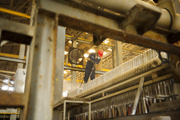 Engineer cleaning machine in factory.