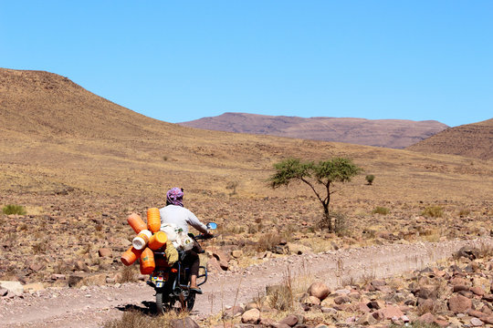 Homme et sa mobylette sur la route désert Sahara Maroc
