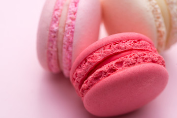 Tasty pink cake macaron or macaroon on pink background. Closeup.