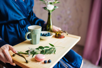 Pastries, macaroons, tea and berries on a wooden background. Breackfast