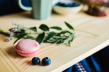Pastries, macaroons and berries on a wooden background