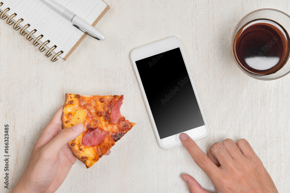 Poster hands ordering pizza with a device over a wooden workspace table