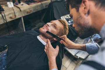 barber combing customers beard