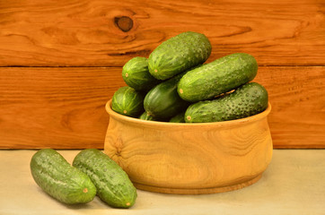 Cucumbers in a bowl on a wooden background