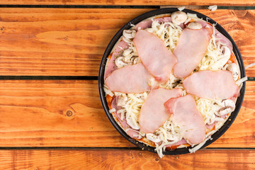Flat lay above pizza with ham cheese mushrooms prepared for baking