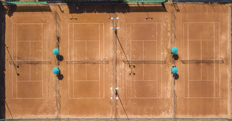 Vista aerea ortogonale di campo da tennis in terra battuta rossa. Ci sono 4 campi ed è estate...