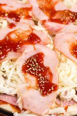 Slice of baked pizza with ham mushrooms ketchup in closeup macro view