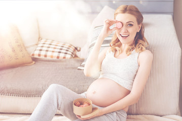 Obraz na płótnie Canvas Positive pregnant woman having rest at home