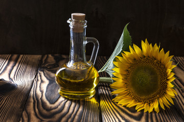 Obraz na płótnie Canvas Vegetable oil is on the table near sunflower