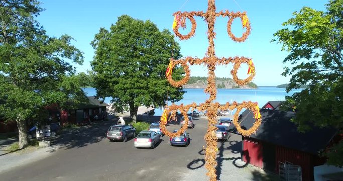 Midsummer pole, Cinema 4k aerial rising view of a maypole, in bromarf town, on a sunny morning, in Bromarv, Uusimaa, Finland
