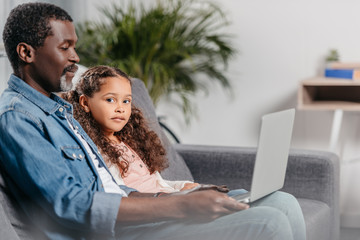 Father with daughter using laptop