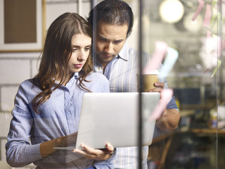 Business man and woman looking at laptop computer