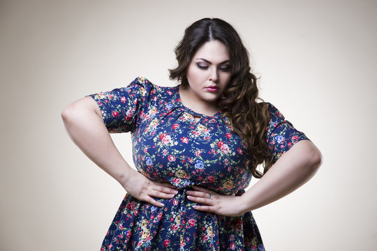 Plus size fashion model in casual clothes, fat woman on beige background, overweight female body