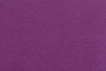 Texture of old dark purple paper closeup. Structure of a dense cardboard. The magenta background.