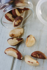 Brazil nuts and glass bottle over the white table