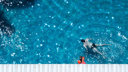 High angle view of swimming pool that father and daughter are playing together.