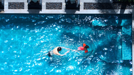 High angle view of swimming pool that father and daughter are playing together.