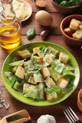 caesar salad and ingredients at wood