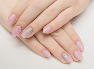 Manicure - Beauty treatment photo of nice manicured woman fingernails. Very nice feminine nail art with nice pink, gold and black nail polish.