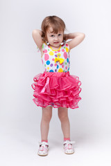 Девочка в ярком платье делает гимнастические упражнения