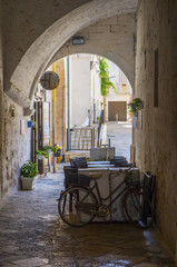 Fototapeta na wymiar Summer terrace cafe in a narrow arched passageway of Polignano a Mare, Italy.