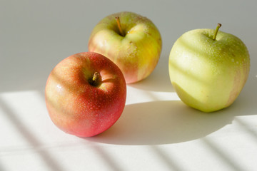 3 apples with water droplets on white background