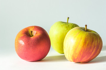 3 apples with water droplets on white background